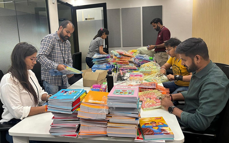 Infosys volunteers assembling stationery kits for children at a local government school